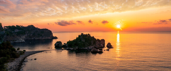 amazing view to a sunrise or sunset above beautiful isle in sea with nice coasline and clouds on the background of the evening sea landscape