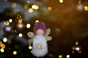 christmas angel on a festive christmas tree background with bokeh lights