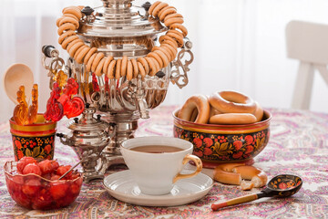 Russian traditions. Tea drinking with a samovar. Still life with a cup of tea, bagels, dried fruits, apple jam, caramel cockerel and Russian samovars. © Юлия Клюева