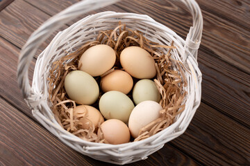 Eggs from purebred chickens with a different shade of shell, eggs from Easter chickens in a white basket