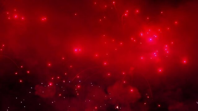 Colorful fireworks festival. Beautiful red fireworks close-up view in slow motion. Wonderful real fireworks in the night sky shot with a telephoto lens. fireworks show. 4K slow motion video.