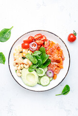 Salmon salad for ketogenic diet with shrimp, avocado, spinach, cucumber, tomato, cashew nuts, sesame. Low-carbohydrate breakfast rich in healthy fats. White table background, top view