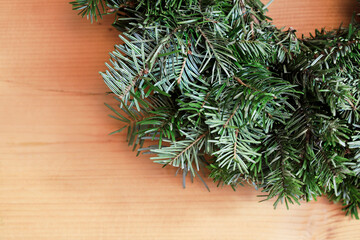 A detail of fir wreath on wooden table.