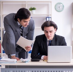 Two young employees working in the office