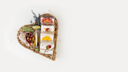 Natural homemade soap wrapped in handmade pressed flower paper lie in a heart shaped basket. Corporate or personal gift idea. Gift for Women's Day, Valentine's Day, Mother's Day.