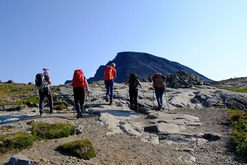 Scenic Besseggen trail in Jotunheimen, Norway - the most beautiful trekking trail in Norway. Silhouettes of hiking tourists on trail.