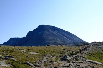 Scenic Besseggen trail in Jotunheimen, Norway - the most beautiful trekking trail in Norway. Silhouettes of hiking tourists on trail.