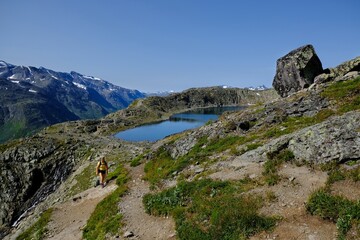 Scenic Besseggen trail in Jotunheimen, Norway - the most beautiful trekking trail in Norway. Silhouettes of hiking tourists on trail.