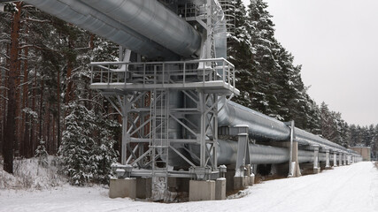 pipeline,pictured pipeline in winter against the background of a snow-covered forest and gray sky