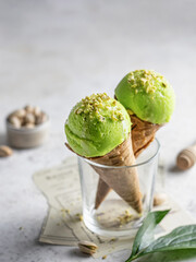 Two pistachio ice cream cones in a glass with chopped pistachios and honey with text space. Valentines day treat