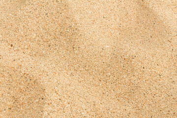 Sand texture and background. Natural beige light yellow sandy beach soft focus.