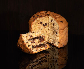 Panettone biscuit with chocolate cream on black glass and chocolate filling