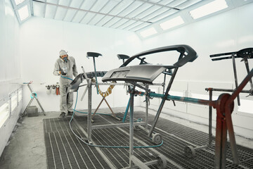 Worker doing color restoration for car parts