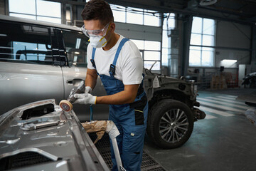 Male cleaning surface of auto, prepare for repair