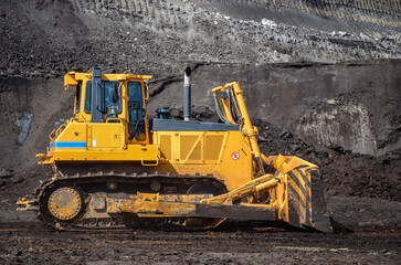 Crawler dozer working on construction site or quarry. Mining machinery moving clay, smoothing gravel surface for new road. Earthmoving, excavations, digging on soils © Leszek Szelest