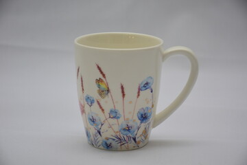 Colorful set of White Ceramic Tea or Coffee mug with Blue red flowers and butterflies on it , isolated on white background