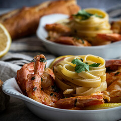 Shrimp scampi served with fettuccini pasta and a crusty baguette