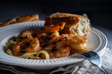 Shrimp scampi served with fettuccini pasta and a crusty baguette