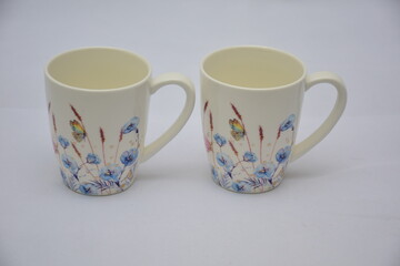 Colorful set of White Ceramic Tea or Coffee mug with Blue red flowers and butterflies on it , isolated on white background