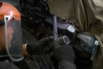 Professional male working in the garage, repairs cars