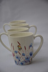 Colorful set of White Ceramic Tea or Coffee mug with Blue red flowers and butterflies on it , isolated on white background