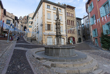Fototapeta na wymiar La place des tables est un passage presque incontournable depuis le bas du Puy-en-Velay pour accéder à la Cathédrale Notre-Dame-du-Puy avec sa fontaine du 15ième siècle