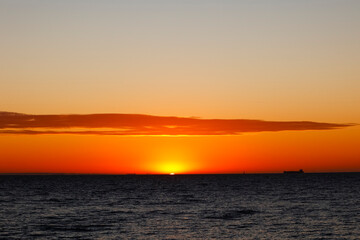 The sun sets over the beach in Melbourne on a summer evening