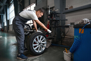 Fototapeta Professional worker checking technical condition of car wheel obraz