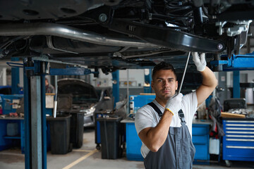 Fototapeta na wymiar Portrait of mechanic replacing car parts in tire shop