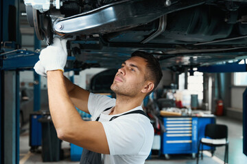 Portrait of young engineer replacing car parts in tire shop