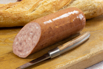 saucisson à l'ail et baguette de pain sur un planche à découper	