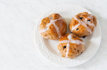Homemade traditional hot cross buns with fruit and raisins.