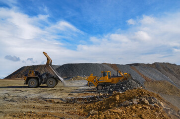 Big crawler dozer working on construction site or quarry. Mining machinery moving clay, smoothing gravel surface for new road. Earthmoving, excavations, digging on soils © Leszek Szelest