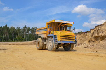 Obraz premium Large dumper truck working in a quarry on bright sunny day