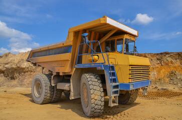 Large dumper truck working in a quarry on bright sunny day