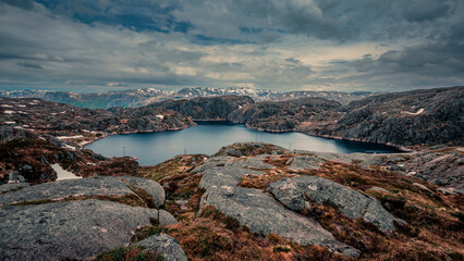 Landscape around Lysefjord in Rogaland with lake in Norway, dark cloudy sky