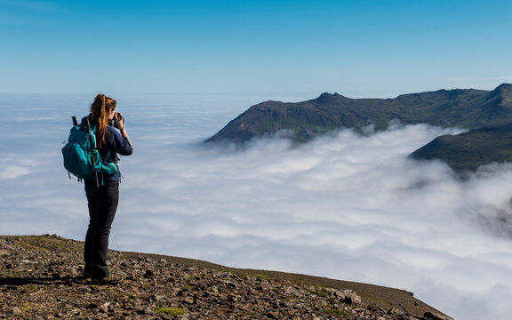 Female hiker taking picture of view,â€ Borgafjordurâ€ Eystri, Iceland