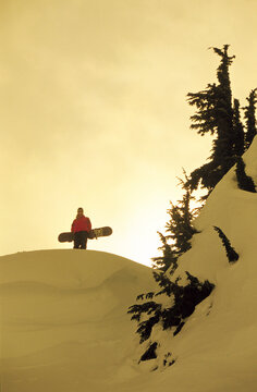 Female snowboarder silohette in backcountry.