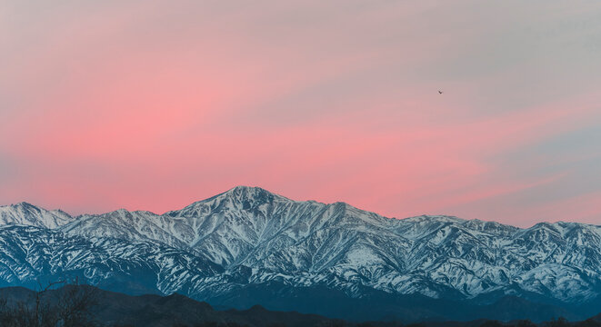 view of the snowy mountain range in the andes with the first lights of