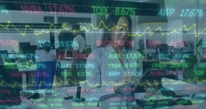 Animation Of Trading Board And Graphs Over Asian Businesswoman Using Digital Tablet In Office