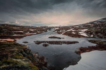 River with snow in the landscape of Hardangervidda National Park in Norway