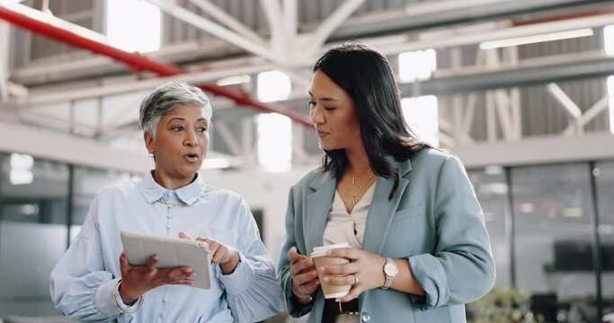 Business, tablet and senior woman with employee, talking and walking in modern office. Women, female administrator and manager speaking, conversation for schedule and leader in workplace or corporate