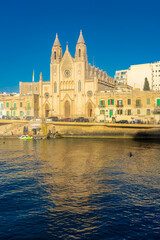 Fototapeta na wymiar Sliema, Malta, 22 May 2022: The Cathedral right on the harbor of Sliema