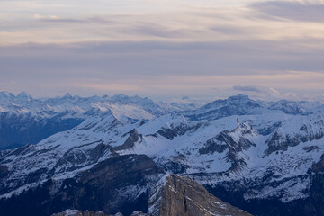 Shot from behind the peaks of the Swiss mountains during the golden hour, perfect for photography.