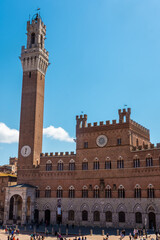 Fototapeta na wymiar Tourists enjoy Piazza del Campo square in Siena, Italy. The historic centre of Siena has been declared by UNESCO a World Heritage Site.