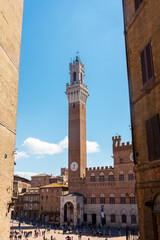 Obraz premium Tourists enjoy Piazza del Campo square in Siena, Italy. The historic centre of Siena has been declared by UNESCO a World Heritage Site.