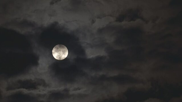 Tokyo, Japan - January 7, 2023: The full moon partially covered with moving clouds
