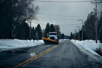 snowplough on a road covered by snow in winter
