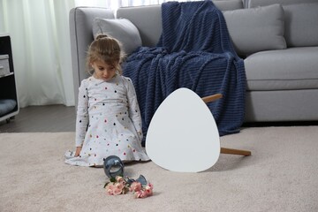 Child and broken ceramic vase on floor at home