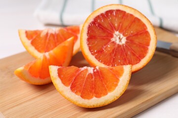 Fototapeta na wymiar Slices of red orange on wooden board, closeup